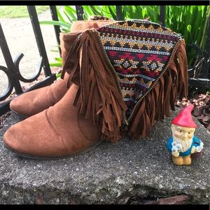 Moccasin ankle boot with tassels and pattern.